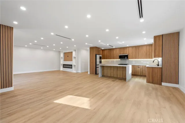 a large kitchen with a lot of cabinets and wooden floor