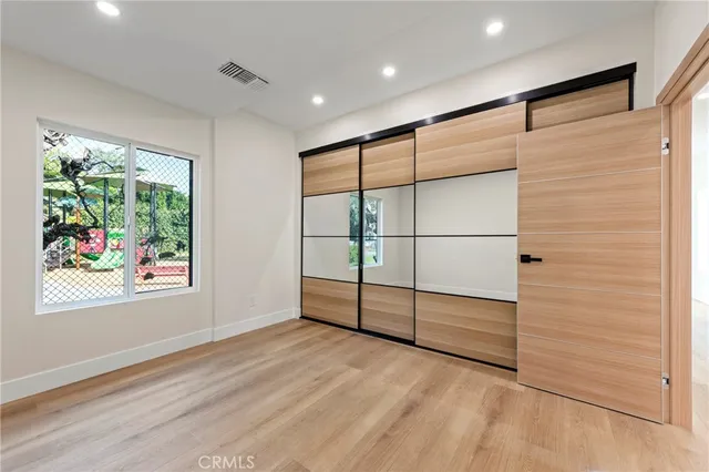 a bathroom with a shower a sink and mirror with toilet