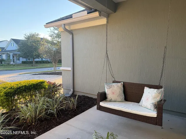 a view of a room with wooden floor chandelier and windows