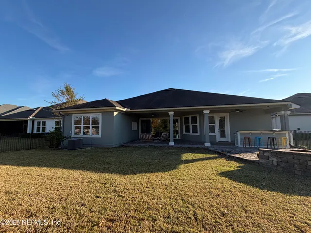 an aerial view of residential houses with outdoor space and trees
