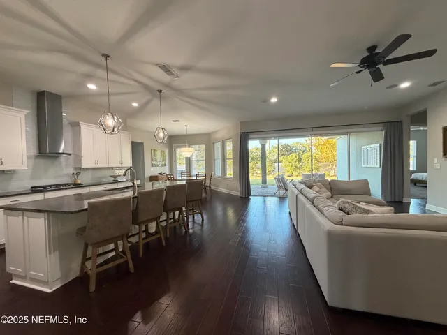 a living room with stainless steel appliances furniture and a view of kitchen