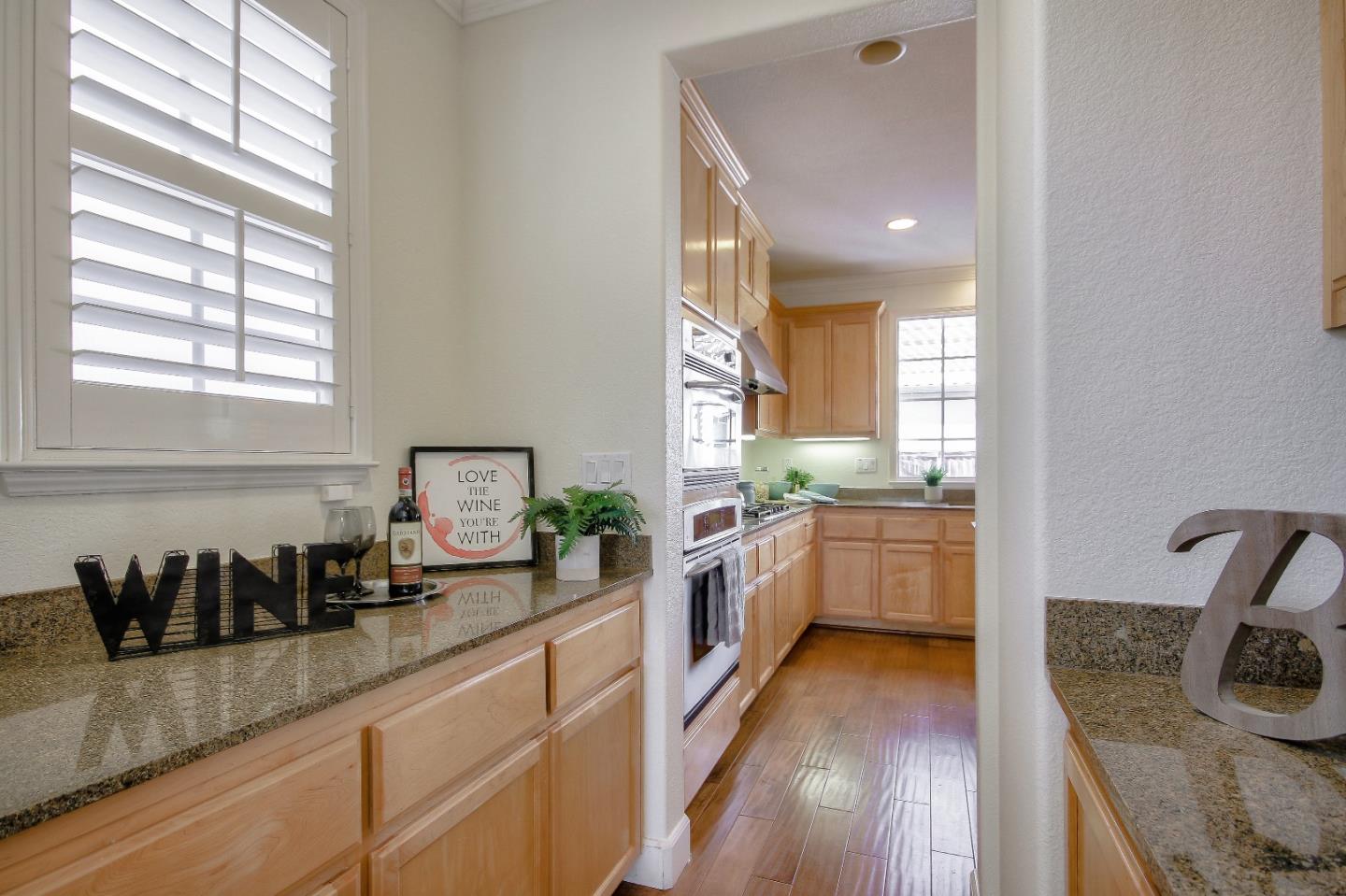 2893 Bethany Road San Ramon, CA 94582 - Photo 15 of 43 a kitchen with granite countertop a stove a sink a refrigerator and wooden floor