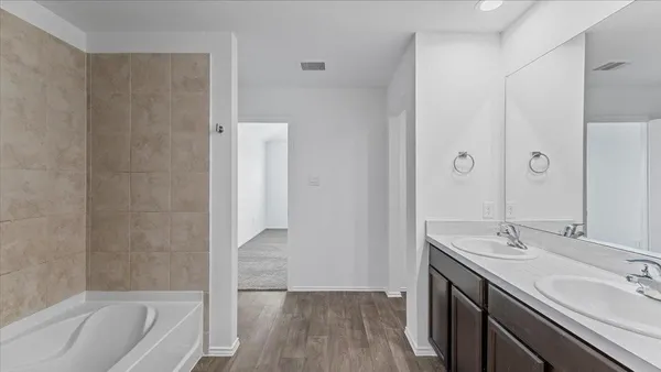 a bathroom with a tub sink and mirror