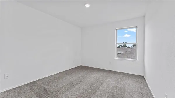 a view of a small space with wooden floor and a window
