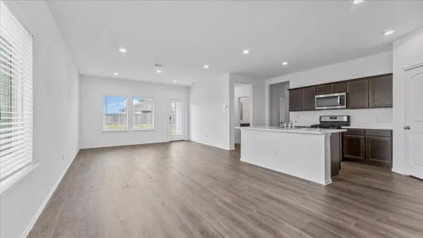 a view of kitchen with wooden floor and electronic appliances