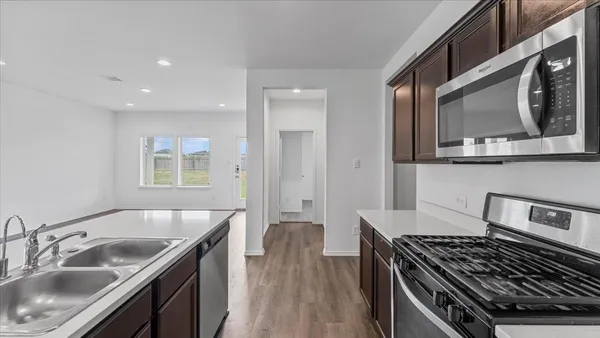 a kitchen with stainless steel appliances granite countertop a sink stove and cabinets