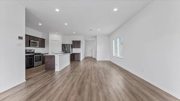 a view of kitchen with wooden floor and electronic appliances