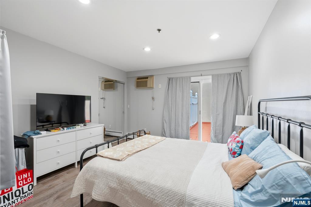 258 Old River Road Edgewater, NJ 07020 - Photo 11 of 32 a bedroom with a bed and flat screen tv