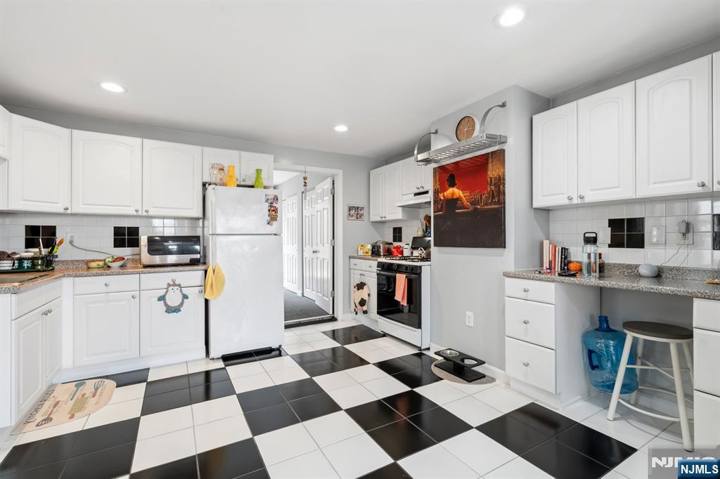258 Old River Road Edgewater, NJ 07020 - Photo 21 of 32 a kitchen with white cabinets a refrigerator and white cabinets