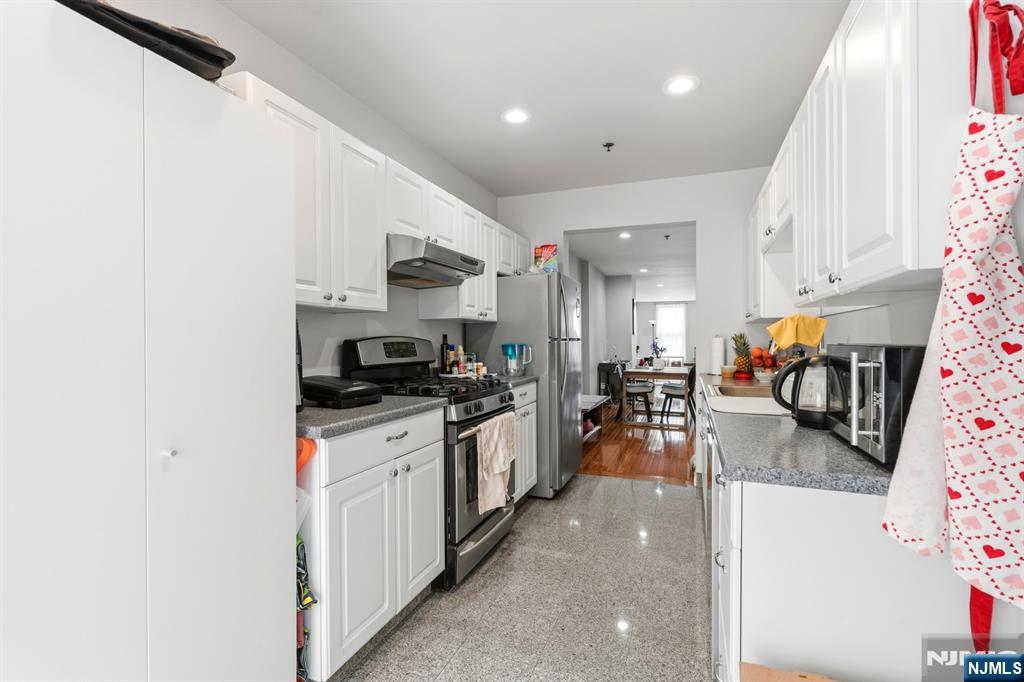258 Old River Road Edgewater, NJ 07020 - Photo 6 of 32 a kitchen with stainless steel appliances granite countertop a refrigerator a stove and a sink