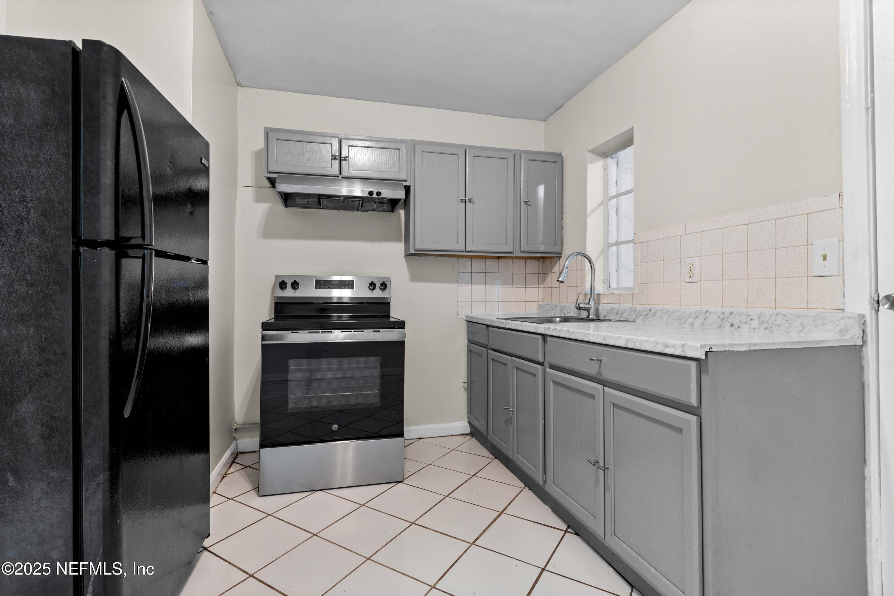 602 Luna Court Jacksonville, FL 32205 - Photo 8 of 16 a kitchen with granite countertop a refrigerator and a sink