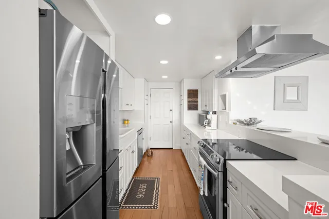 a view of a kitchen with fridge and wooden floor
