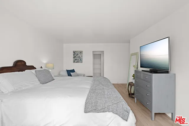 a bedroom with a bed and a flat screen tv