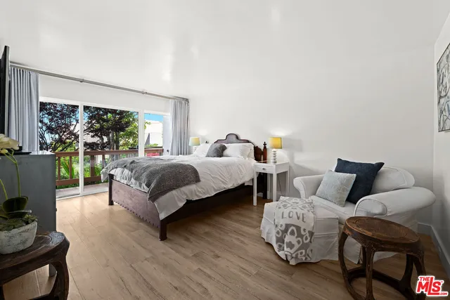 a bedroom with a bed and large windows