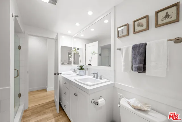 a bathroom with a double vanity sink mirror and bathtub