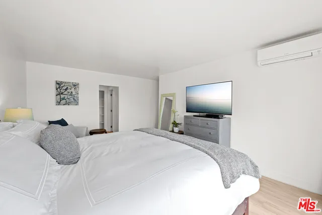 a bedroom with a large bed and a flat screen tv