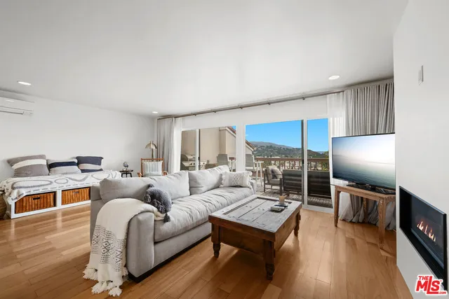a living room with furniture a flat screen tv and a table