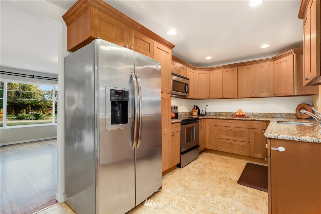 24118 2nd Place West Bothell, WA 98021 - Photo 11 of 25 a kitchen with granite countertop a refrigerator and a sink