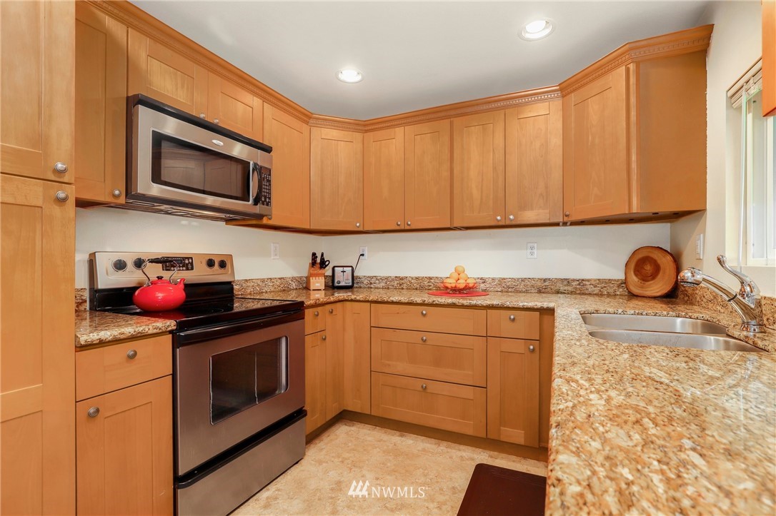 24118 2nd Place West Bothell, WA 98021 - Photo 7 of 25 a kitchen with stainless steel appliances granite countertop a stove top oven a sink dishwasher and cabinets with wooden floor