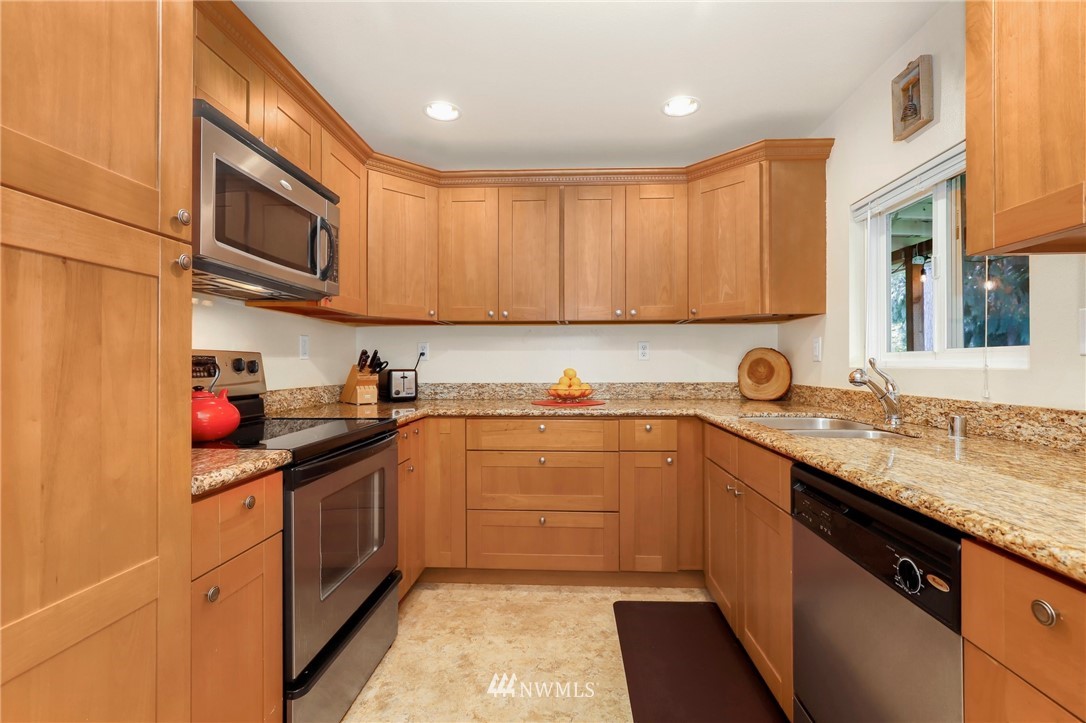 24118 2nd Place West Bothell, WA 98021 - Photo 8 of 25 a kitchen with stainless steel appliances granite countertop a sink stove and cabinets
