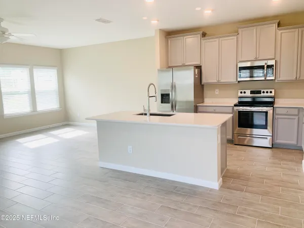 a kitchen with stainless steel appliances a refrigerator sink and stove