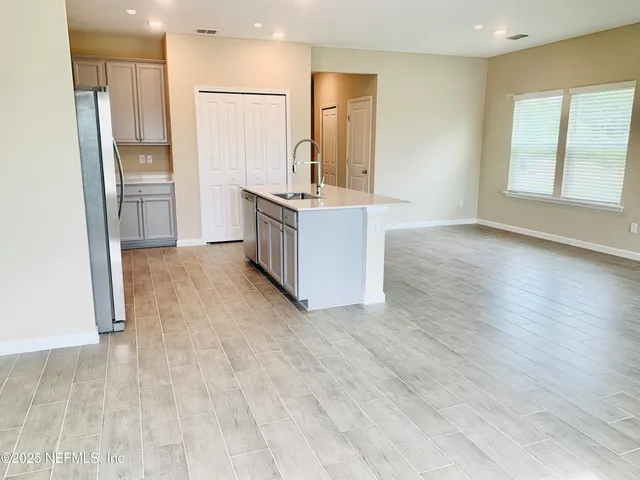 a view of a kitchen with wooden floor and a sink