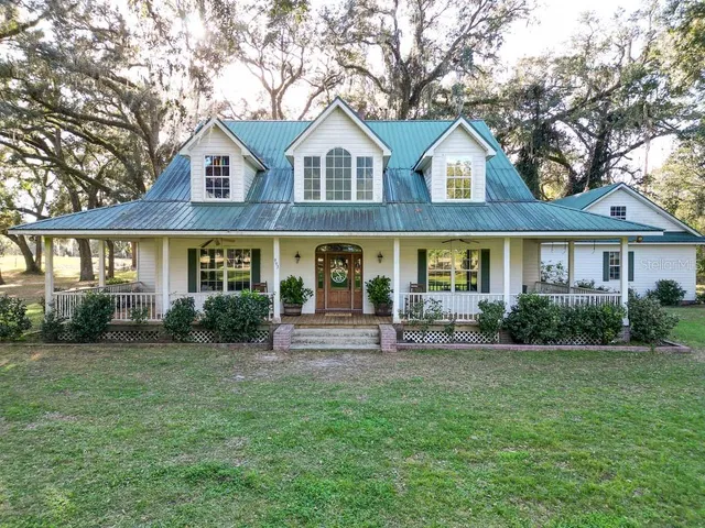 a front view of a house with yard and green space