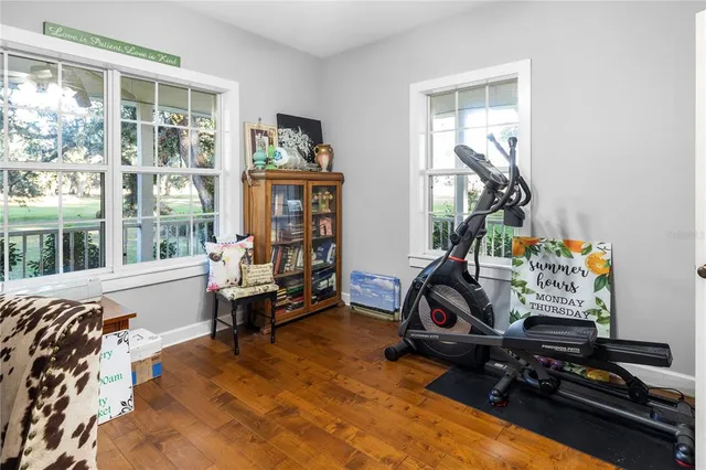 a living room with furniture a flat screen tv and floor to ceiling window