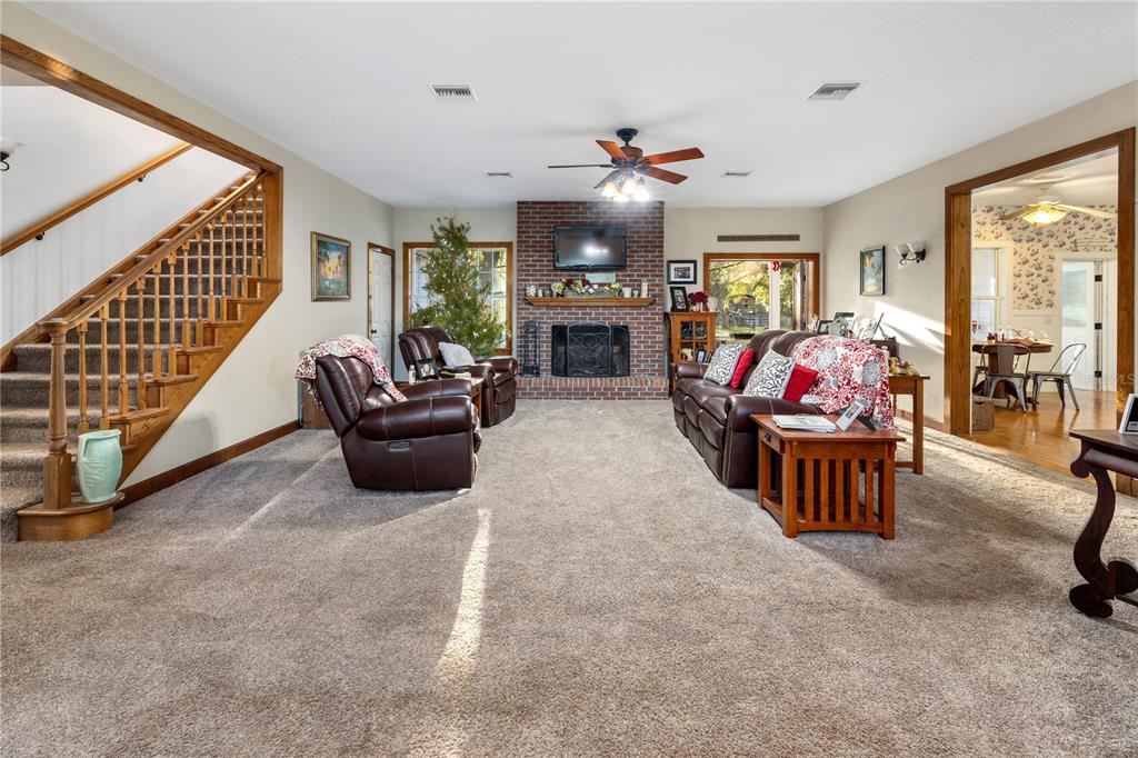 993 Cr 722 Webster Webster, FL 33597 - Photo 37 of 96 a living room with furniture a flat screen tv and floor to ceiling window