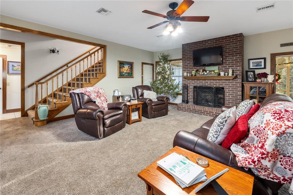 993 Cr 722 Webster Webster, FL 33597 - Photo 38 of 96 a living room with furniture a flat screen tv and a fireplace