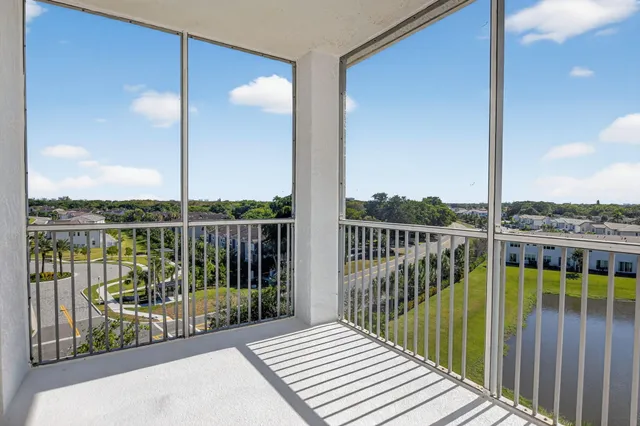a view of a balcony with floor to ceiling window wooden floor and fence