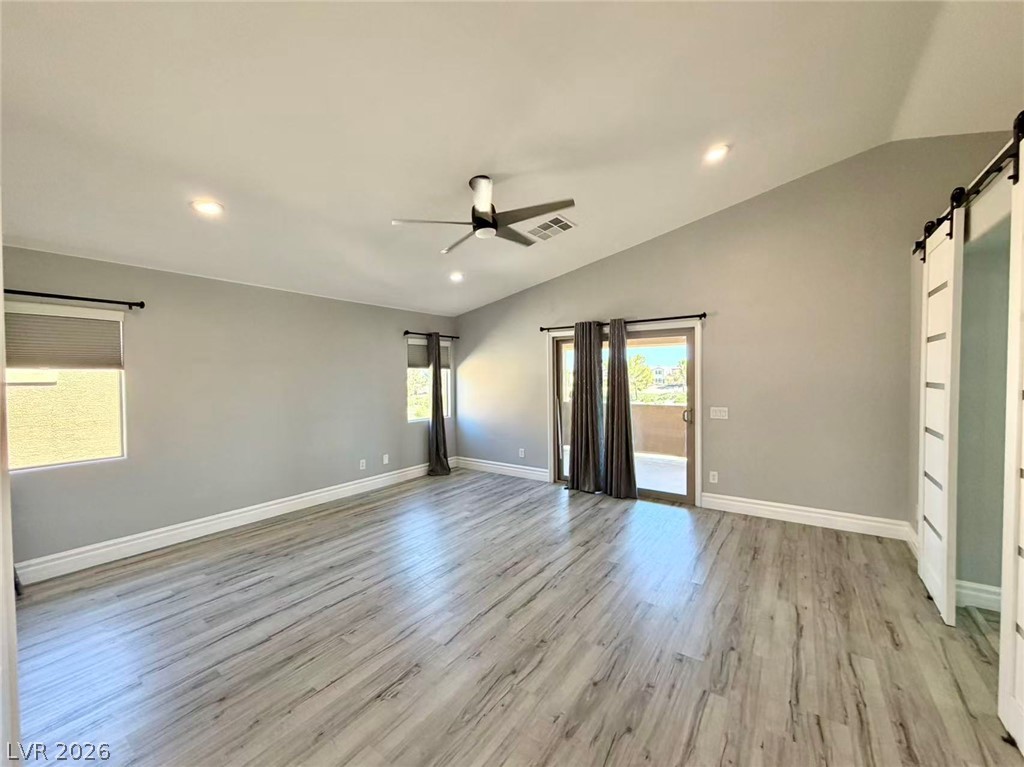 135 Tall Ruff Drive Las Vegas, NV 89148 - Photo 15 of 29 A spacious room features vaulted ceilings, light wood-look flooring, and sliding glass doors opening to a private balcony.