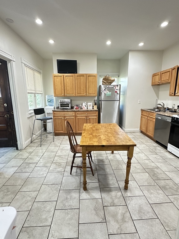 27 Orkney Road, Unit 1 Boston, MA 02135 - Photo 1 of 26 a kitchen with stainless steel appliances kitchen island granite countertop a table chairs and a refrigerator
