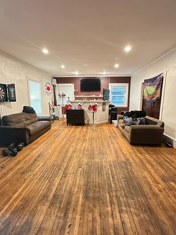 a large bedroom with a bed and wooden floor