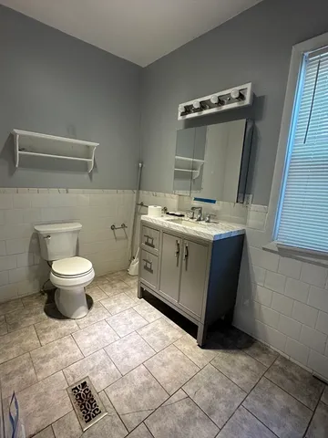 a bathroom with a granite countertop sink a toilet and a mirror