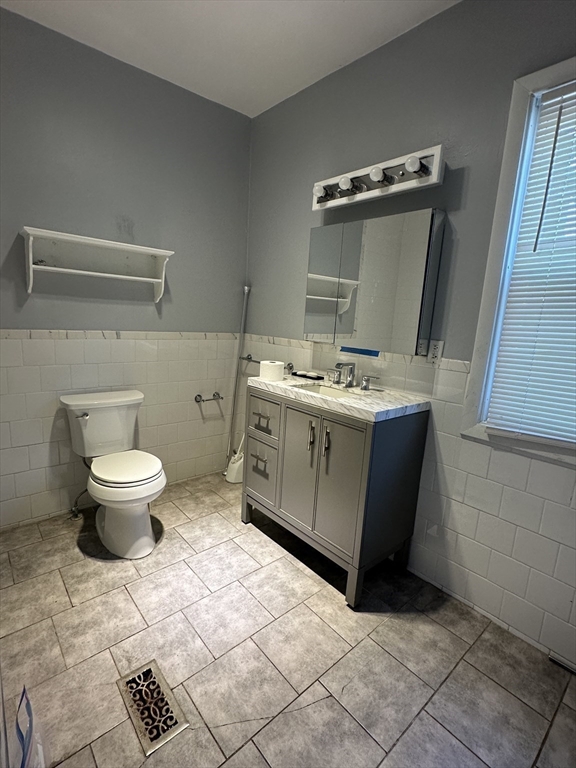 27 Orkney Road, Unit 1 Boston, MA 02135 - Photo 8 of 26 a bathroom with a granite countertop sink a toilet and a mirror