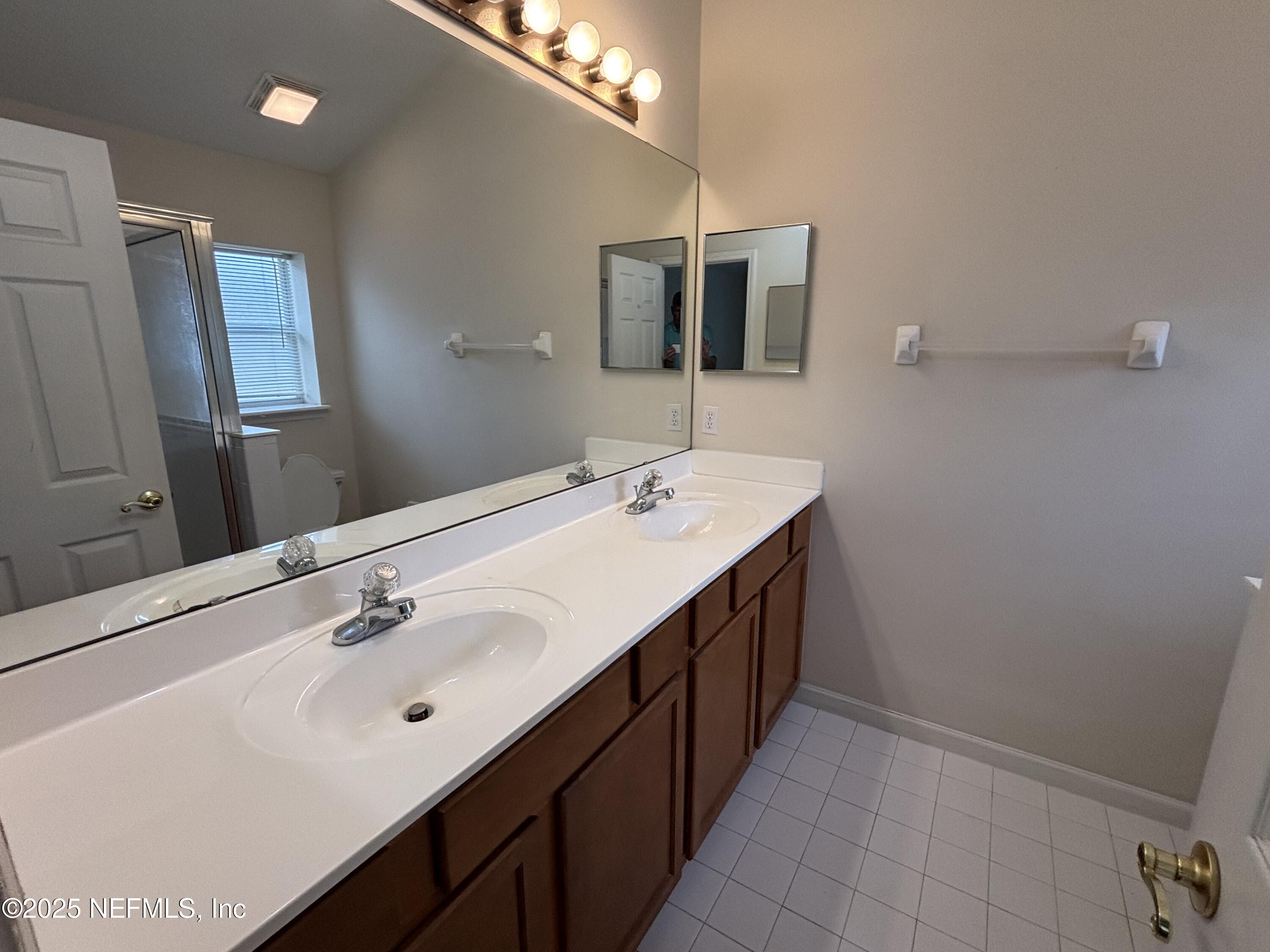 817 Oak Arbor Circle St. Augustine, FL 32084 - Photo 12 of 19 a bathroom with a double vanity sink and mirror