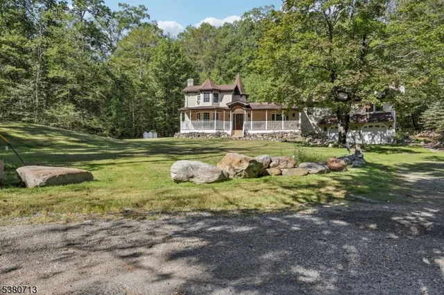a front view of a house with a yard and lake view
