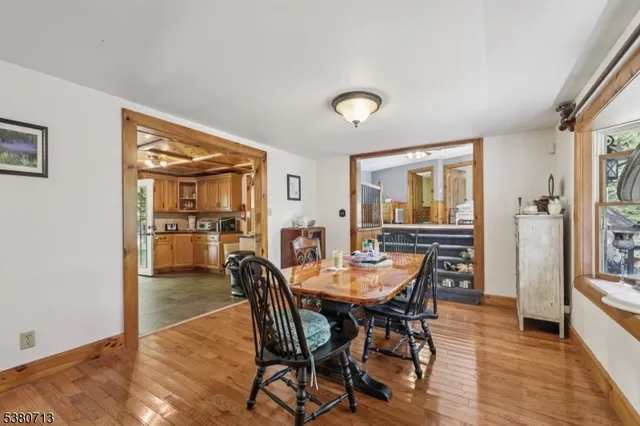 a dining room with furniture a chandelier and wooden floor