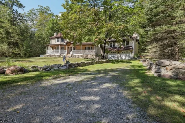 a view of a house with a big yard and large trees