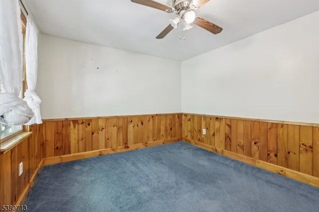 a view of a livingroom with a ceiling fan and window