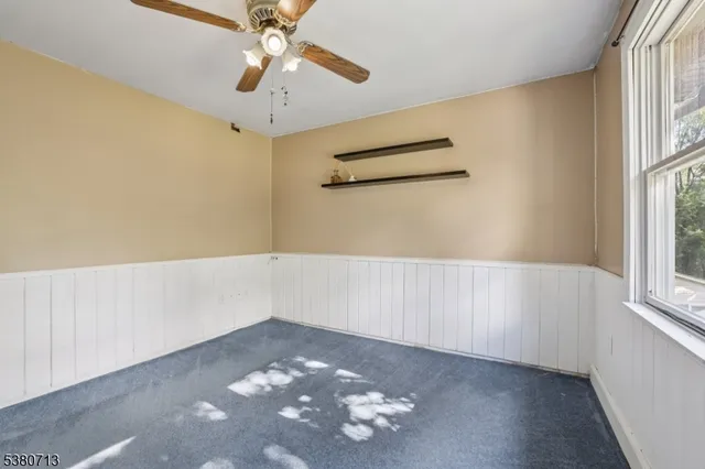 a view of a livingroom with a chandelier fan and a bathroom