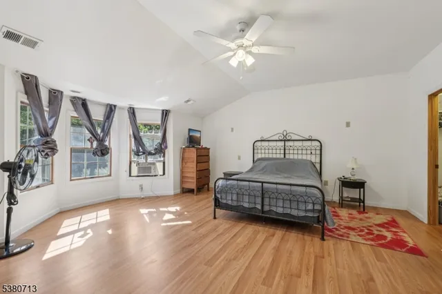a bedroom with a bed and wooden floor