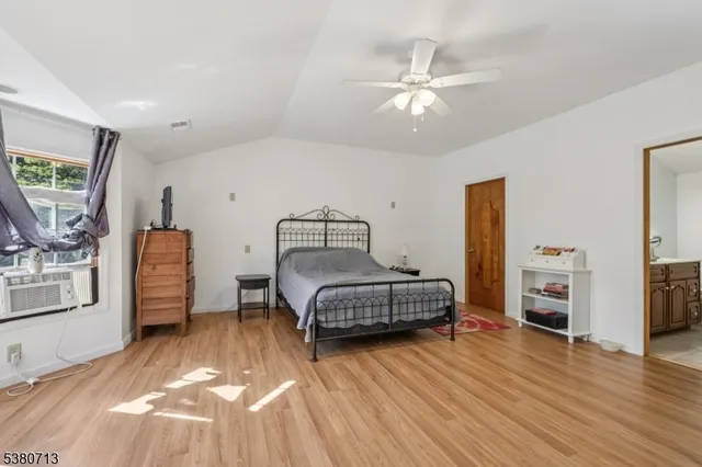 a bedroom with a bed and a chair with potted plant