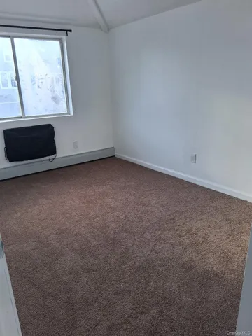 an empty room with wooden floor and a sink