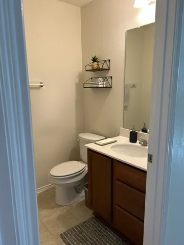 a bathroom with a granite countertop toilet and a sink