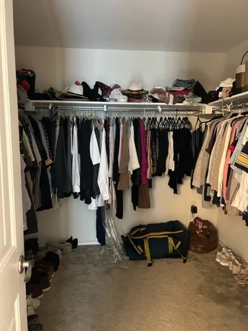 a view of walk in closet with clothes and shoes