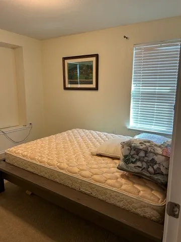 a bedroom with bed and window