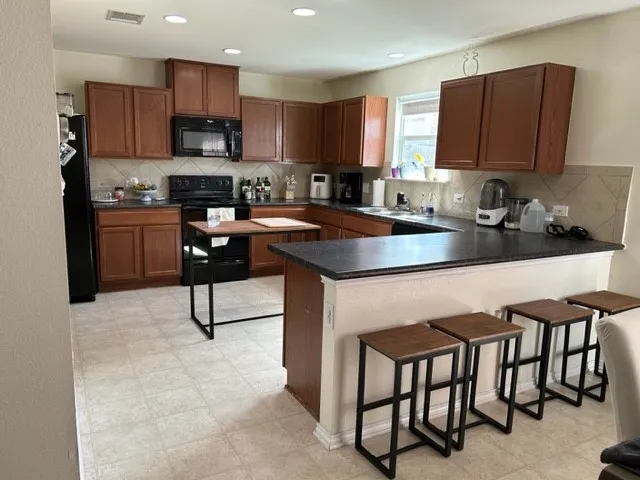 a kitchen with stainless steel appliances granite countertop a stove a sink a microwave and a refrigerator