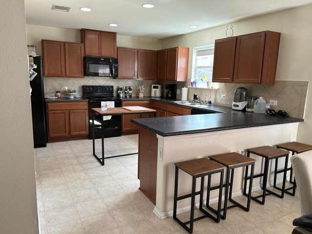 9008 Norwich Castle Austin, TX 78747 - Photo 9 of 26 a kitchen with stainless steel appliances granite countertop a stove a sink a microwave and a refrigerator
